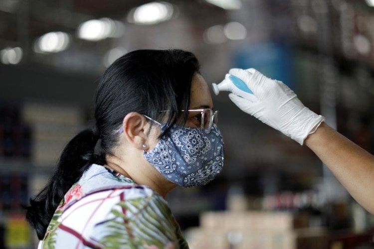 Empleados de supermercados controlan la temperatura de personas que ingresan durante el brote de coronavirus en Brasilia, Brasil, 20 de marzo del 2020. REUTERS/Ueslei Marcelino