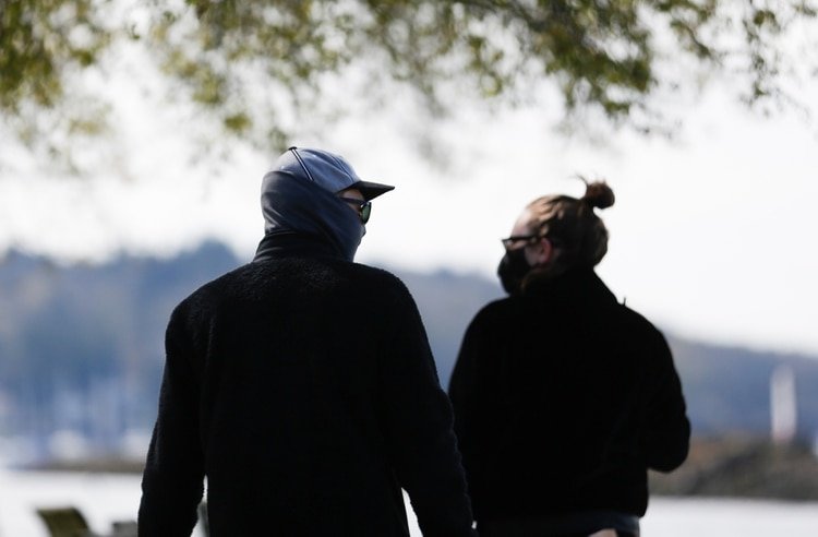 Dos personas usan máscaras al dar un paseo en el Parque Golden Gardens, el día después de que el CDC recomendara usar máscaras faciales no médicas en público, en Seattle, Washington, el 4 de abril de 2020. (REUTERS/Lindsey Wasson)