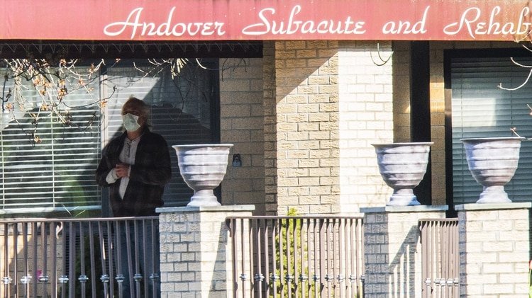 Un hombre está de pie a la entrada del Centro de Rehabilitación y Subagudos de Andover con una máscara el 16 de abril de 2020 (Eduardo Muñoz Álvarez/Getty Images/AFP)
