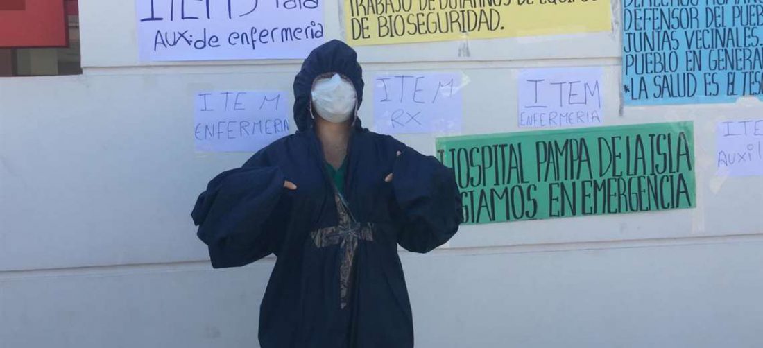 Una trabajadora del Hospital Pampa de la Isla muestra los defectos en los trajes recibidos