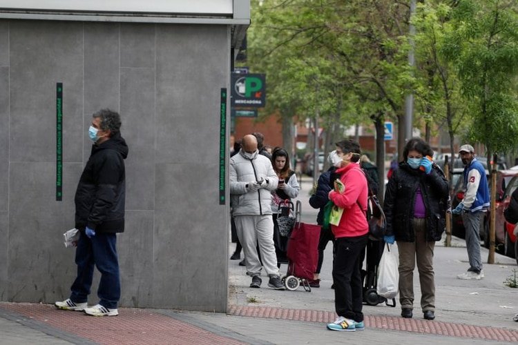 La gente mantiene la distancia social mientras espera entrar en un supermercado en medio del brote de la enfermedad coronavirus (COVID-19) en Madrid, España (REUTERS/Sergio Pérez)