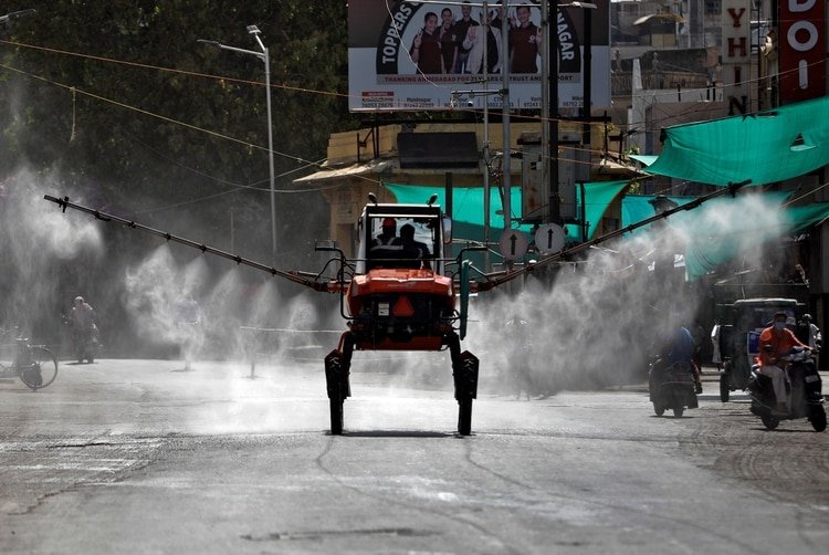Miembros de los Servicios de Bomberos y Emergencias descontaminan una carretera utilizando un pulverizador de aguilón durante un cierre nacional para frenar la propagación del coronavirus (Reuters)