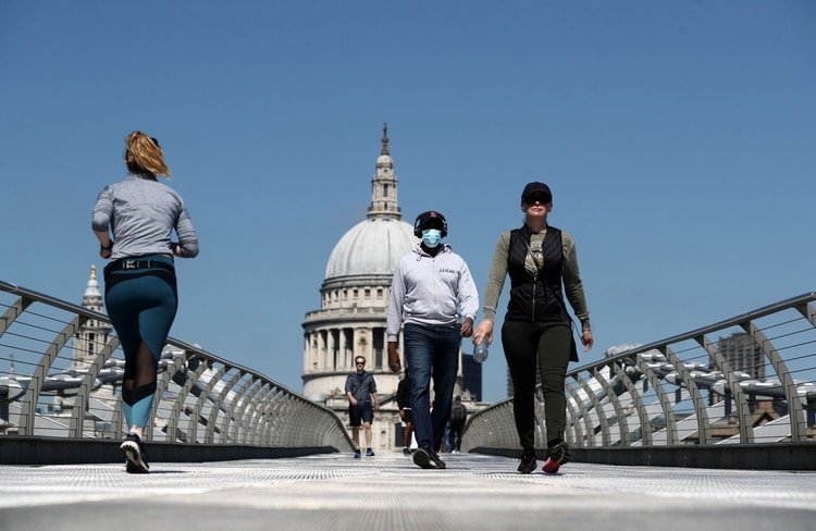 Gente con máscaras cruzan el Puente Millennium, en Londres, Reino Unido (REUTERS/Simon Dawson)