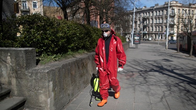 Un trabajador municipal rocía desinfectante en las calles del centro de Vilna antes de levantar la cuarentena. /AP Photo/Mindaugas Kulbis)