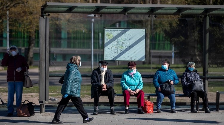 Personas con mascarillas aguardan un autobús en el centro de la capital lituana.