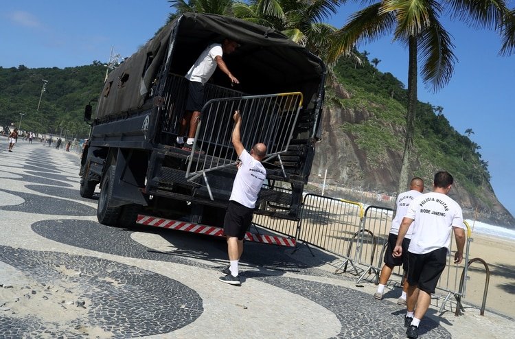 Policías militares remueven las vallas que impedía el acceso a la playa en Copacabana, Río de Janeiro (REUTERS/Pilar Olivares)