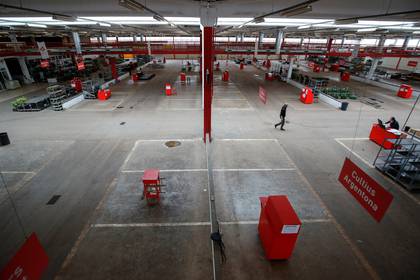 Un hombre camina por los puestos vacíos del "Mercat de Flor i Planta Ornamental de Catalunya", al norte de Barcelona, el 22 de abril de 2020 (REUTERS/Albert Gea)
