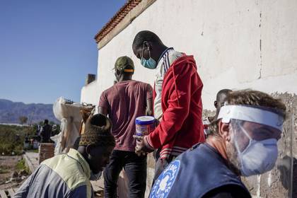 Miembros de la ONG Médicos del Mundo distribuyen alimentos a migrantes de Malí en San Isidro, durante el brote de la enfermedad por coronavirus (COVID-19) en Níjar, en la región de Almería, España, 29 abril 2020 (REUTERS/Juan Medina)