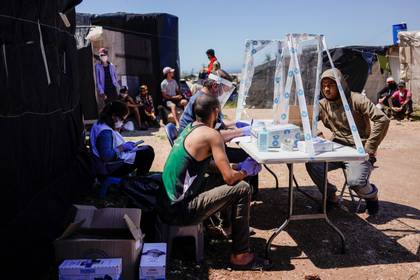 Miembros de la ONG española Médicos del Mundo prestan atención médica a un migrante de Marruecos en un barrio de chabolas conocido como El Hoyo, durante el brote de la enfermedad coronavírica (COVID-19) en Níjar, en la región de Almería, España, el 29 de abril de 2020. Foto tomada el 29 de abril de 2020. (REUTERS/Juan Medina)