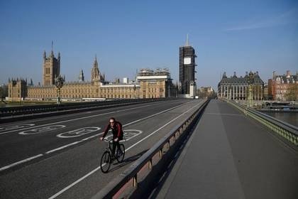 Un ciclista pasa por el puente de Westminster mientras continúa la propagación de la enfermedad coronavirus (COVID-19), Londres, Reino Unido, 10 de abril de 2020. REUTERS/Toby Melville