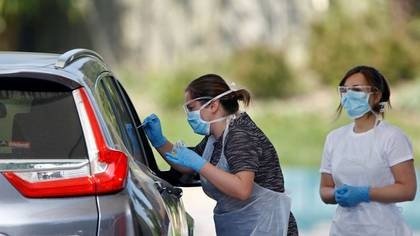 FOTO DE ARCHIVO: Dos trabajadoras sanitarias llevan a cabo pruebas de detección de la enfermedad del nuevo coronavirus (COVID-19) a conductores en un punto de control en Chessington, Londres, Reino Unido,el 24 de abril de 2020. REUTERS/Henry Nicholls