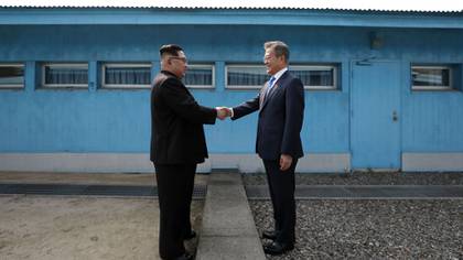 El líder de Corea del Norte, Kim Jong Un (izq.), estrecha la mano del presidente de Corea del Sur, Moon Jae-in (der.), en la Línea de Demarcación Militar que divide a sus países.