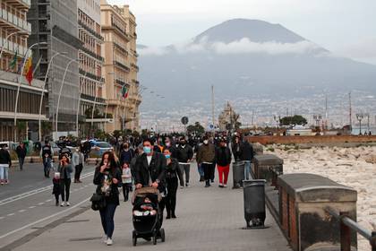 Personas caminan en el paseo marítimo de Nápoles. (REUTERS/Ciro De Luca)