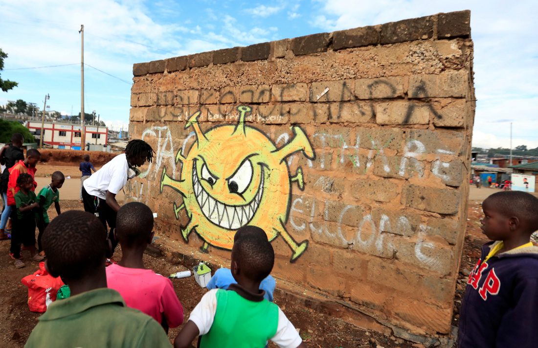 Niños observan a Brian Musasia Wanyande terminando su graffiti en el barrio popular del Valle de Mathare en Nairobi, Kenia