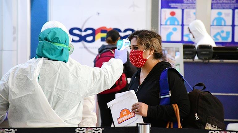 El personal del aeropuerto controla la temperatura a pasajera que aborda un vuelo solidario, el jueves. | CARLOS LÓPEZ