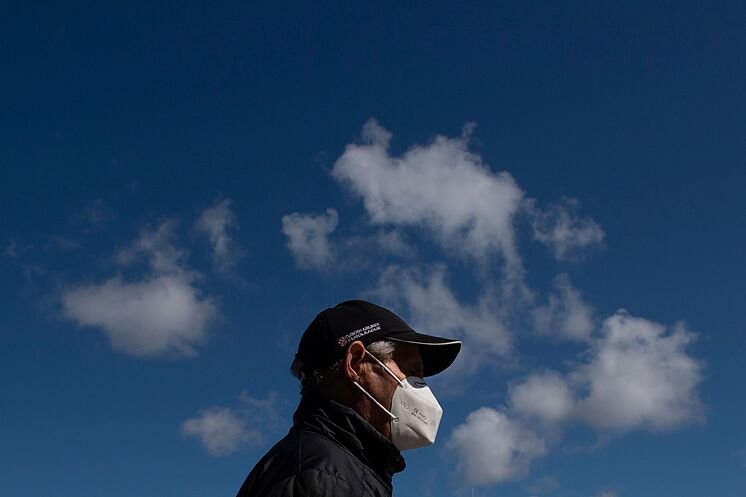 Un hombre con mascarilla contra el coronavirus pasea por Madrid.
