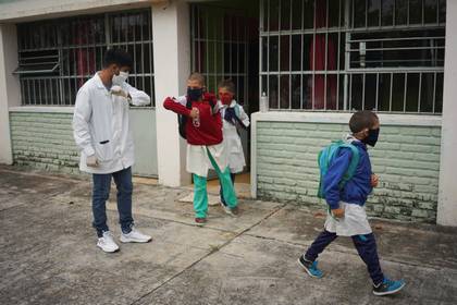 El maestro saluda con el codo a sus alumnos (REUTERS/Mariana Greif)