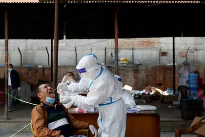 Una toma de muestra por hisopado para hacer un test de PCR en un mercado en Kathmandu, Nepal (REUTERS/Navesh Chitrakar)