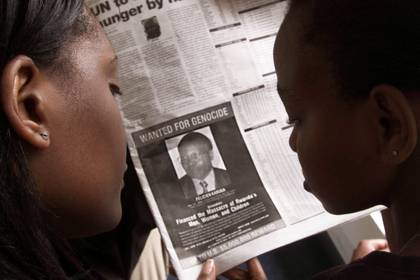 Lectores miran un periódico del 12 de junio de 2002 en Nairobi que lleva la fotografía del ruandés Felicien Kabuga buscado por los Estados Unidos (REUTERS/George Mulala/File Photo)
