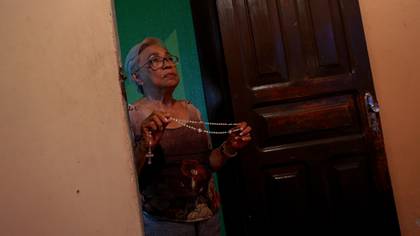 María rezando por el eterno descanso de sus hijos y cuñados (MICHAEL DANTAS / AFP)