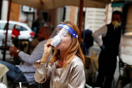 Una mujer toma un café en un bar mientras Italia alivia algunas de las medidas de cierre implementadas durante el brote de coronavirus este lunes en Roma (REUTERS / Yara Nardi)