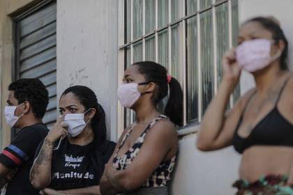 En la imagen se registró a un grupo de residentes de la favela de Mandela, en la zona norte de Río de Janeiro (Brasil), a la esperar de alimentos y ayudas, durante la actual pandemia por el COVID-19. EFE/Antonio Lacerda/Archivo