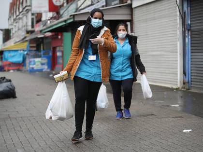 Mujeres caminas por la calle con mascarillas tras hacer las compras en Sparkhill, Reino Unido. 
