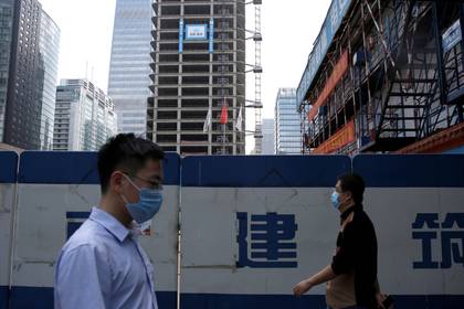 Dos personas caminan con barbijo en Beijing, en pleno brote de coronavirus (REUTERS/Tingshu Wang)