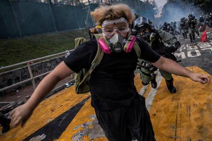 Un manifestante antigubernamental es perseguido por policías antidisturbios después de escaramuzas en la Universidad China de Hong Kong, el 12 de noviembre de 2019 (REUTERS/Tyrone Siu)