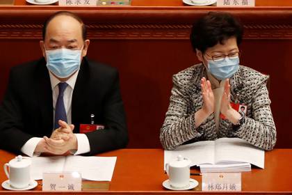 La Directora General de Hong Kong, Carrie Lam (derecha), y el Director General de Macao, Ho Iat-seng (izquierda), asisten a la sesión de apertura del Congreso Nacional del Pueblo (NPC) en el Gran Salón del Pueblo de Beijing, China, el 22 de mayo de 2020 (REUTERS/Carlos Garcia Rawlins)