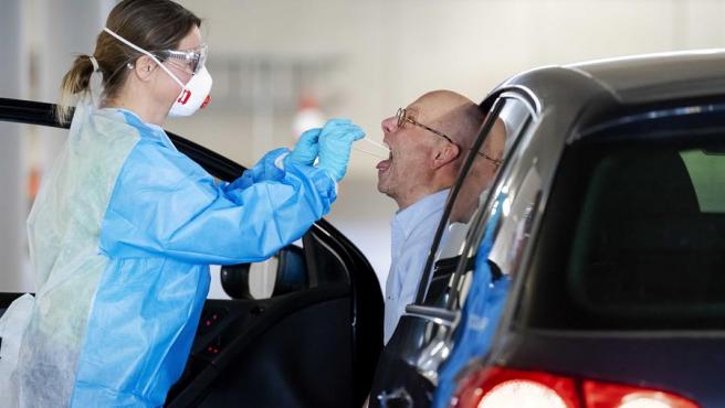 Un trabajador de la salud recoge una muestra de un conductor en un autocine en Rotterdam, Holanda.