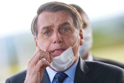 Imagen de archivo del presidente de Brasil, Jair Bolsonaro, ajustándose la mascarilla a su salida del Palacio de Alvorada en Brasilia, Brasil. 13 mayo 2020. REUTERS/Adriano Machado