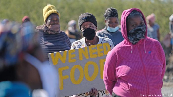 Pobladores de Rustenburg, en África del Sur, piden alimentos durante la cuarentena.