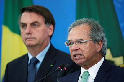 FOTO DE ARCHIVO. El ministro de Economía de Brasil, Paulo Guedes, habla junto al presidente, Jair Bolsonaro, durante un comunicado de prensa que anuncia medidas económicas, en medio del brote de la enfermedad por coronavirus (COVID-19), en Brasilia, Brasil. 1 de abril de 2020. REUTERS/Ueslei Marcelino