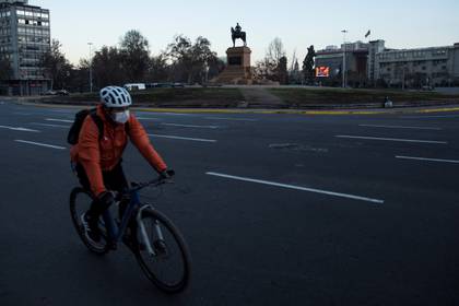 Un ciclista con mascarilla como medida para evitar el contagio con coronavirus pasa frente a la Plaza Italia el 16 de mayo de 2020 en Santiago (Chile). EFE/Alberto Valdés