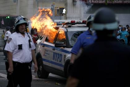 Un patrullero es incendiado durante la protesta en Brooklyn (Reuters)
