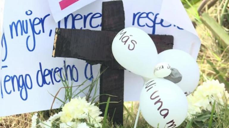 Una cruz y globos don inscripciones para pedir el alto a los feminicidios. | Agencias