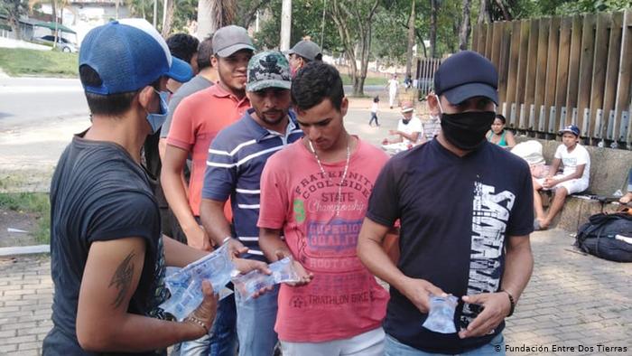 Refugiados venezolanos reciben agua en el camino hacia la frontera, de regreso a su país. 
