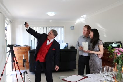 Lou Szymkow se toma una selfie con la pareja Peter Andrews y Hoang Nguyen después de oficiar una boda privada a el domicilio, en Sydney, Australia (imagen tomada el 19 de mayo de 2020. REUTERS/Loren Elliott)