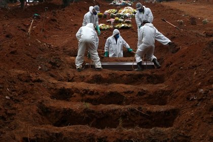 Sepultureros con trajes protectores entierran el ataúd de José Soares, de 48 años, quien murió a causa del coronavirus (COVID-19), en el cementerio de Sao Luiz, en San Pablo, Brasil (REUTERS/Amanda Perobelli)