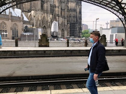 Un pasajero con una máscara protectora camina en un andén cerca de una famosa catedral gótica en Colonia, Alemania, el 10 de junio de 2020 (REUTERS/Gabriela Baczynska)