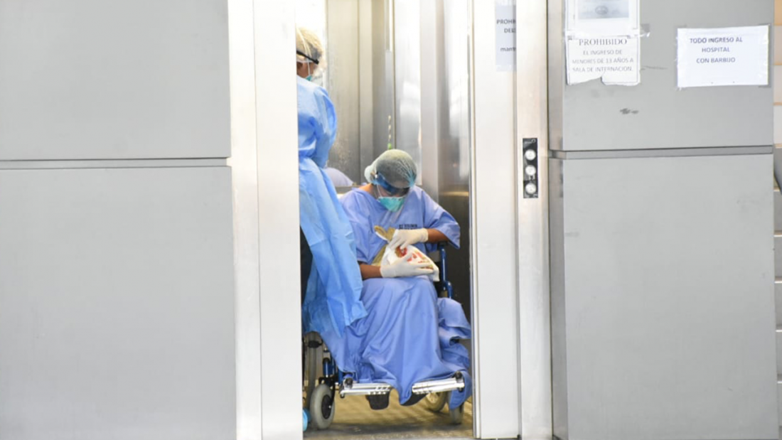 Un paciente con COVID-19 y un miembro del personal médico se trasladan a otra sala de atención a través del ascensor. DICO SOLÍS.