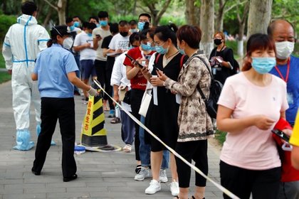 Personas hacen fila usando mascarillas en China 